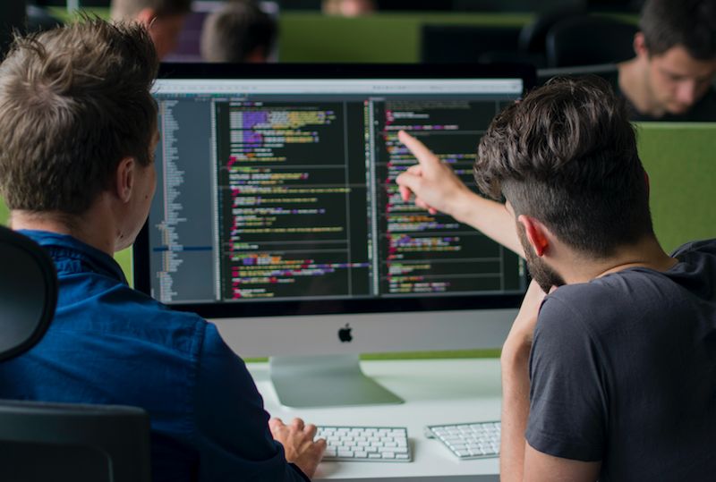 Equipo de desarrollo revisando código en pantalla