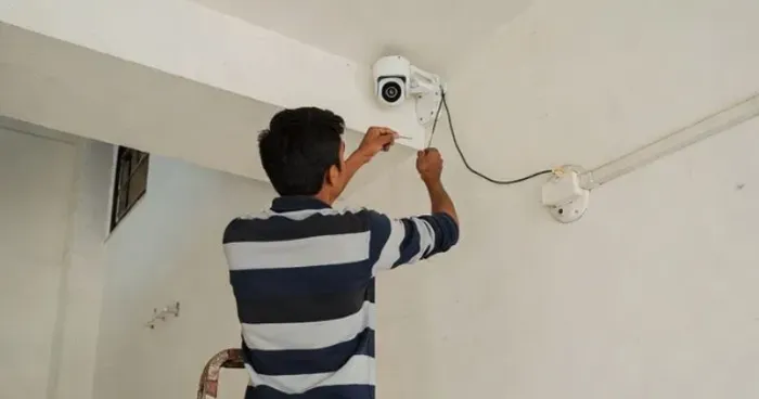 Técnico instalando una cámara de seguridad EZVIZ en el techo de un local